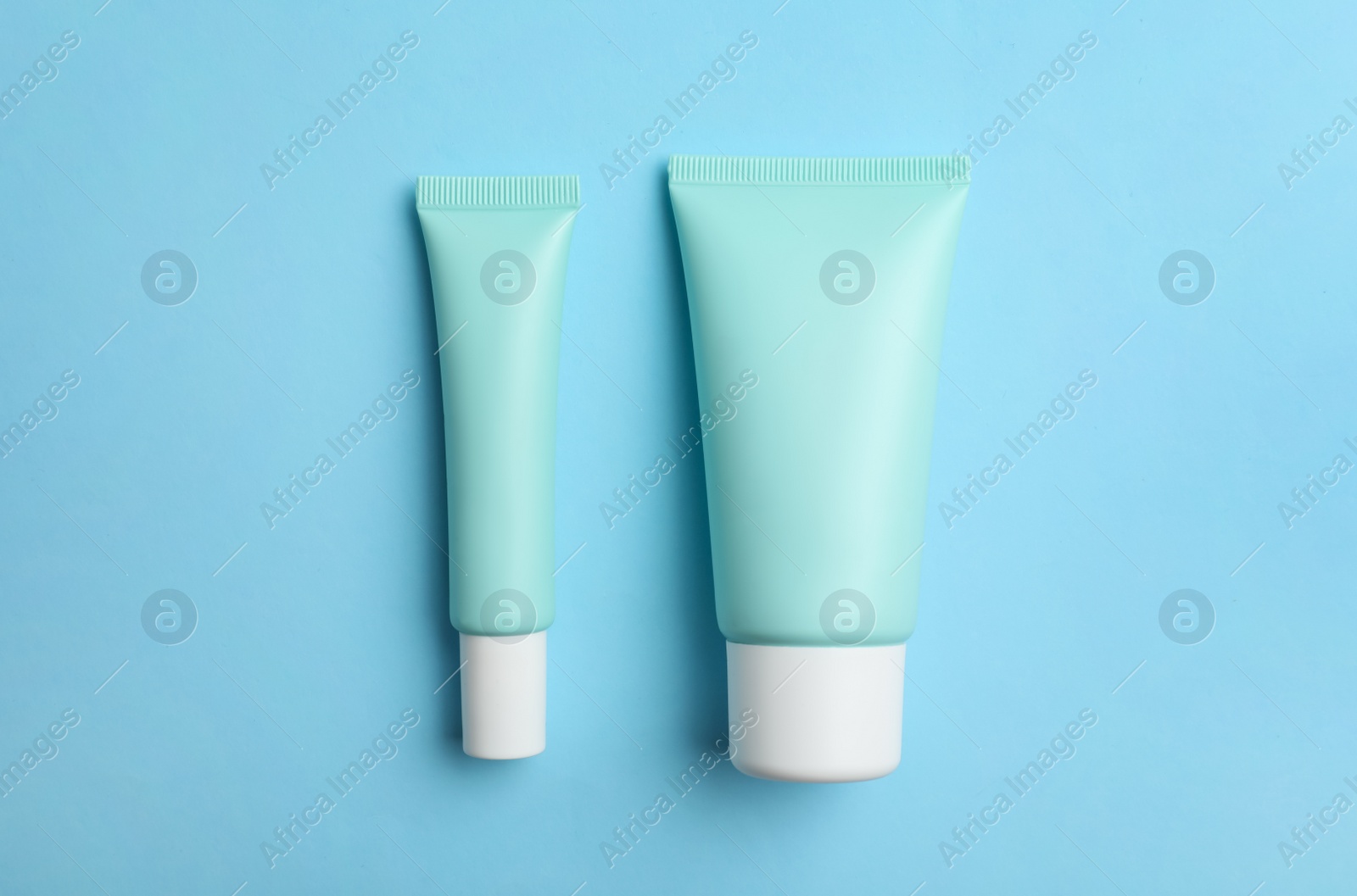 Photo of Set of luxury cosmetic products on light blue background, flat lay.