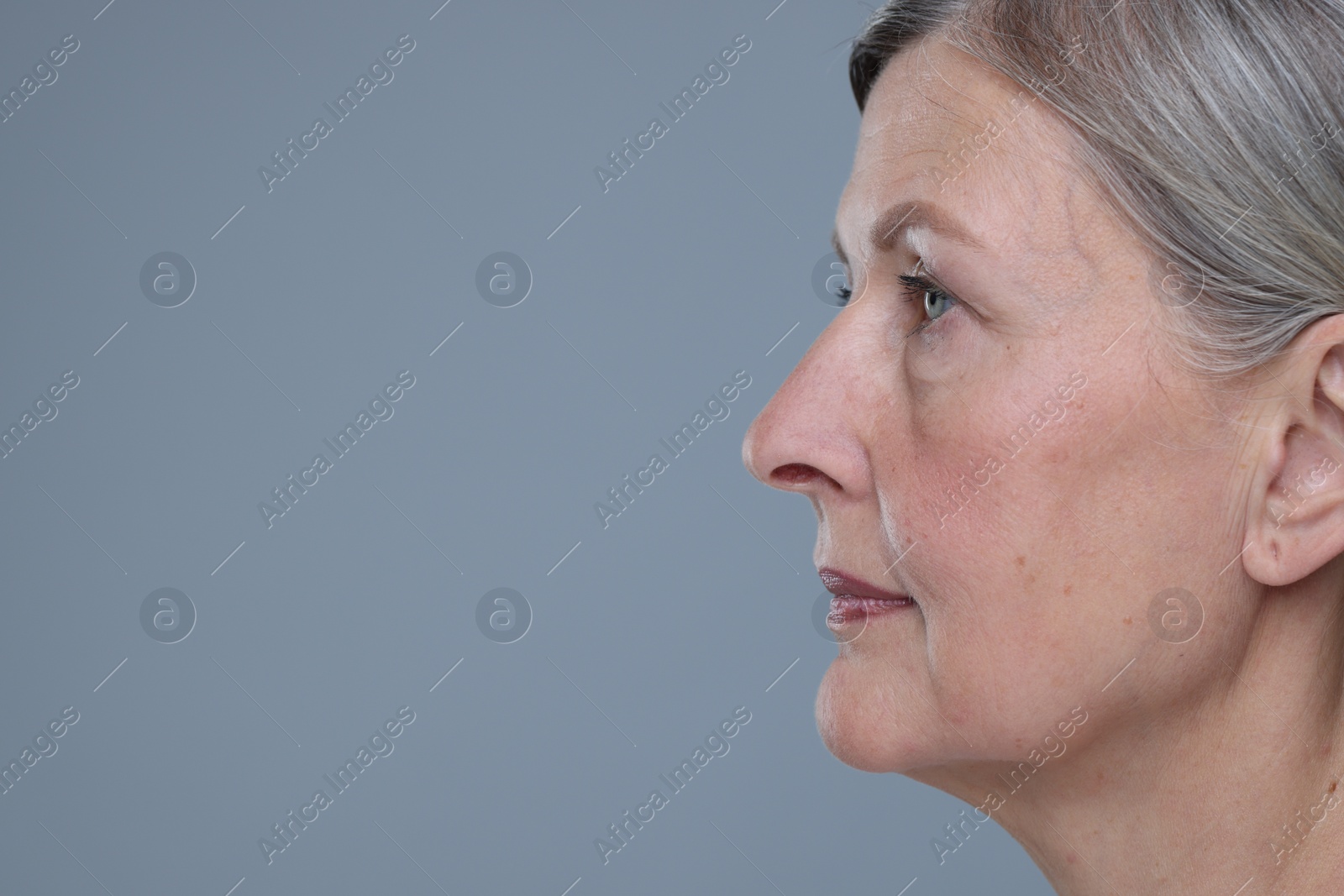 Photo of Senior woman with aging skin on grey background, closeup and space for text. Rejuvenation treatment