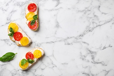 Photo of Tasty fresh tomato bruschettas on marble table, flat lay. Space for text