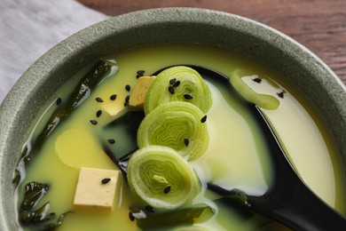 Photo of Bowl of delicious miso soup with tofu and spoon, closeup