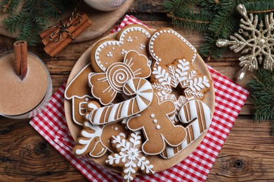Photo of Delicious gingerbread Christmas cookies on wooden table, flat lay