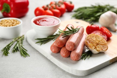 Photo of Delicious vegetarian sausages with rosemary and vegetables on grey table