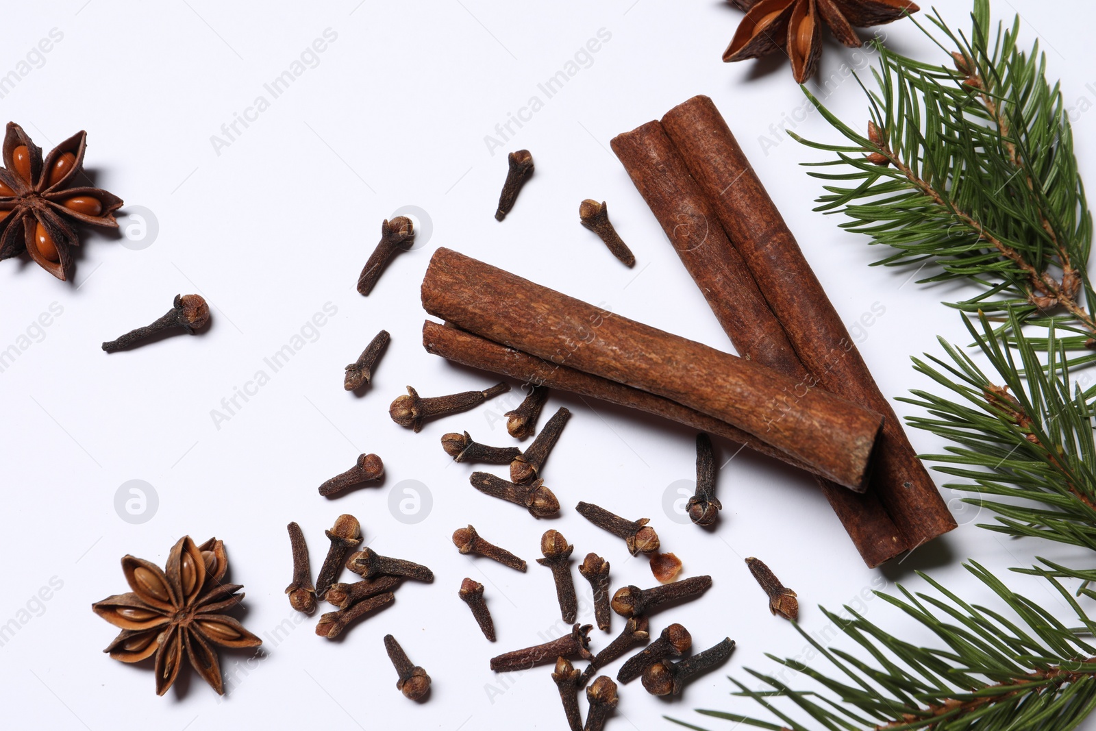 Photo of Different spices and fir branches on white table, flat lay