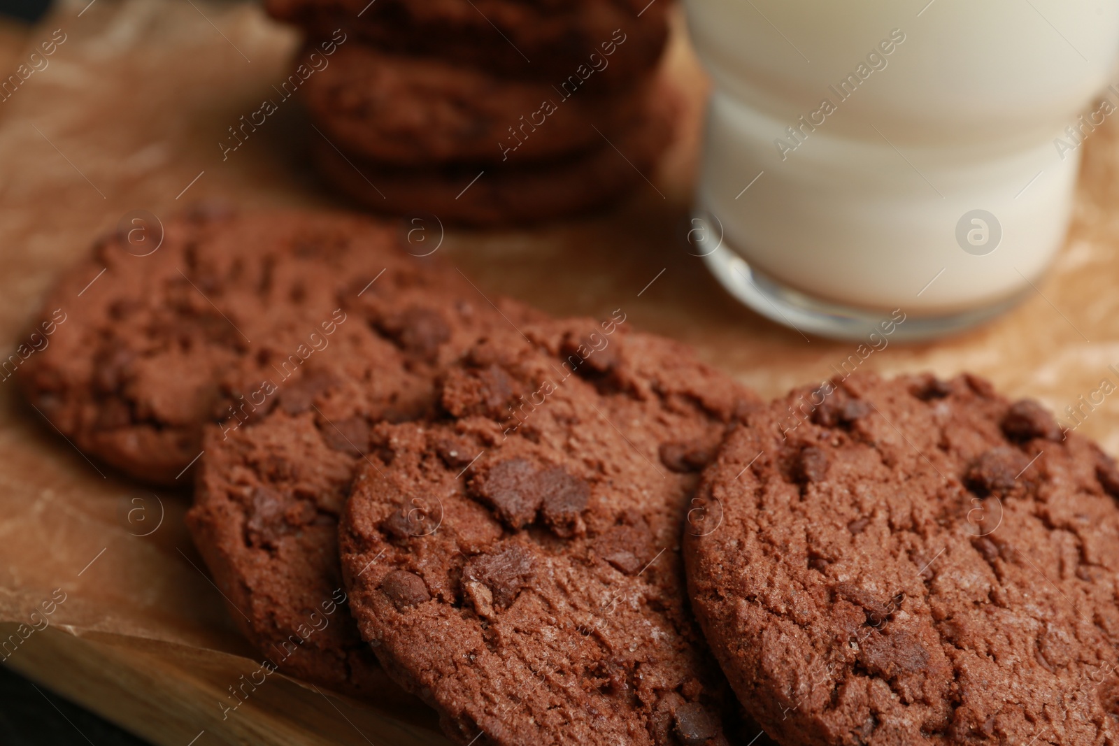 Photo of Tasty chocolate cookies on wooden board, closeup