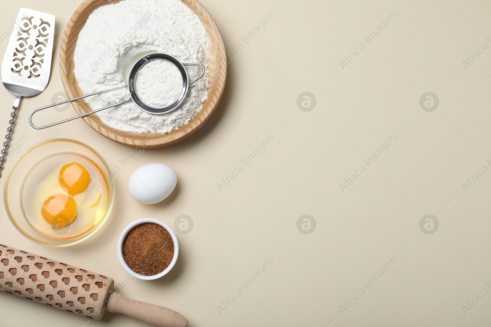 Photo of Cooking utensils and ingredients on beige background, flat lay. Space for text