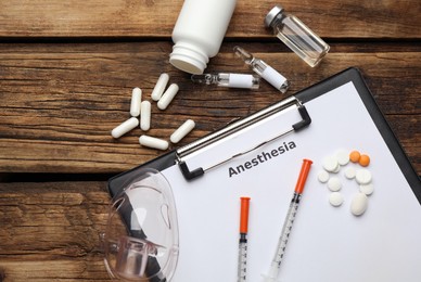 Photo of Flat lay composition of clipboard with word Anesthesia and drugs on wooden table