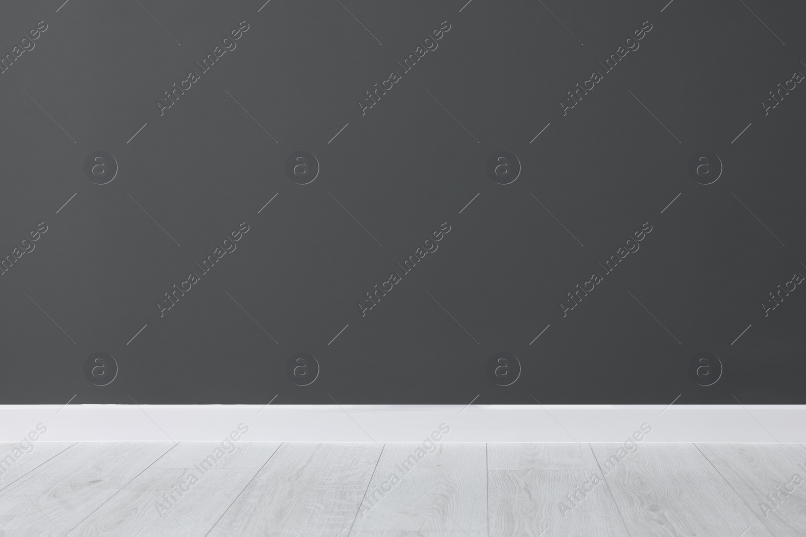 Photo of Beautiful dark grey wall and wooden floor in clean empty room