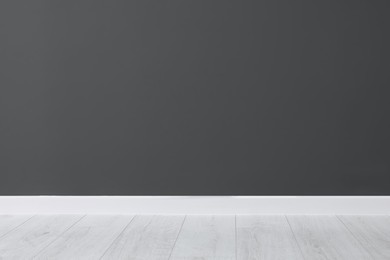 Beautiful dark grey wall and wooden floor in clean empty room