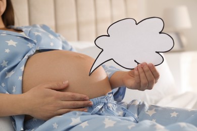 Photo of Pregnant woman with empty paper thought cloud indoors, closeup. Choosing baby name