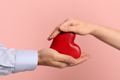 Photo of Man and woman with decorative heart on color background, closeup