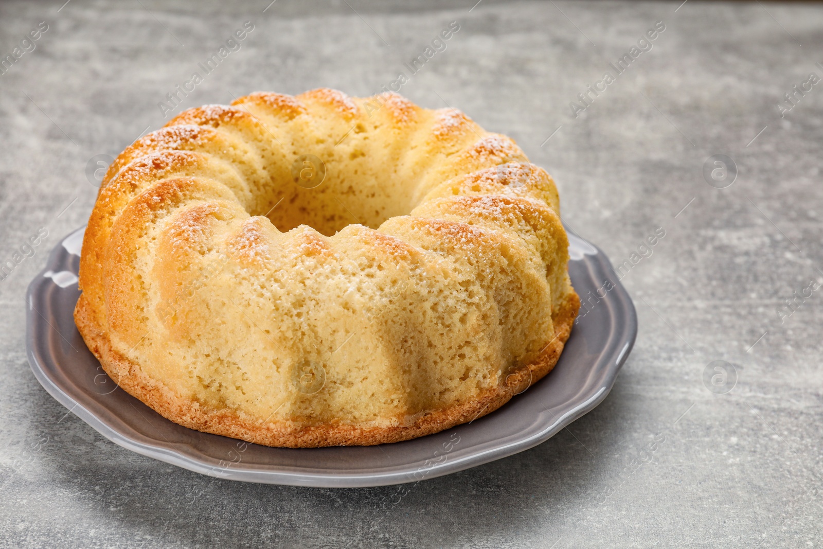 Photo of Delicious freshly baked sponge cake on gray table, closeup. Space for text