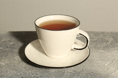 Aromatic tea in cup on grey table