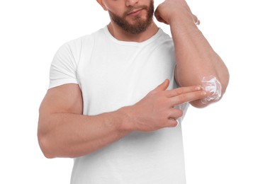 Man applying body cream onto his elbow on white background, closeup