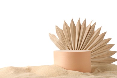 Photo of Presentation of product. Beige podium and palm leaf on sand against white background