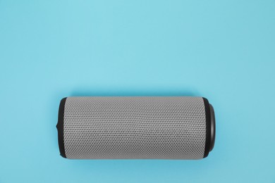 Photo of One portable bluetooth speaker on light blue background, top view with space for text. Audio equipment