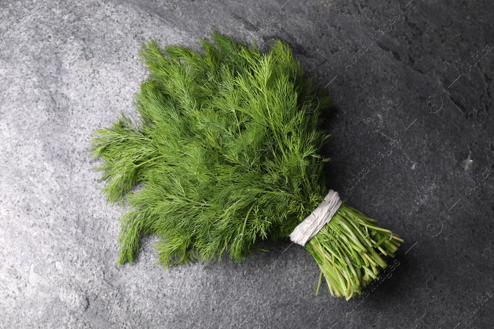 Photo of Bunch of fresh green dill on grey table, top view