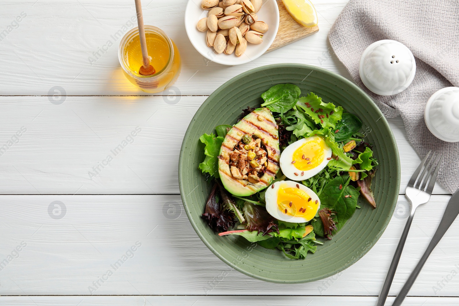 Photo of Healthy dish high in vegetable fats served on white wooden table, flat lay. Space for text