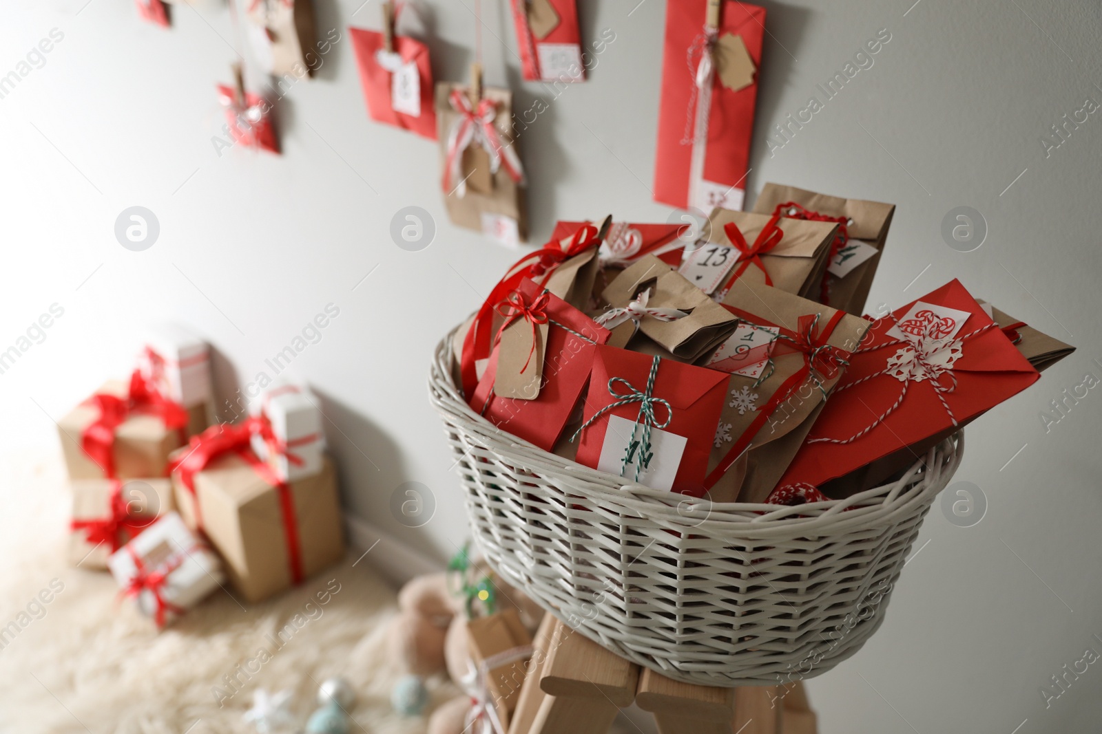 Photo of Making Christmas advent calendar. Basket full of paper bags with gifts