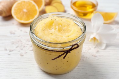 Photo of Body scrub in glass jar on white wooden table, closeup
