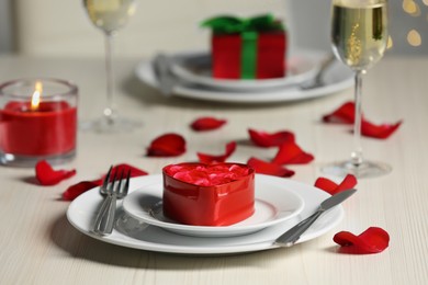 Photo of Beautiful table setting with decorative heart shaped box with roses for romantic dinner, closeup