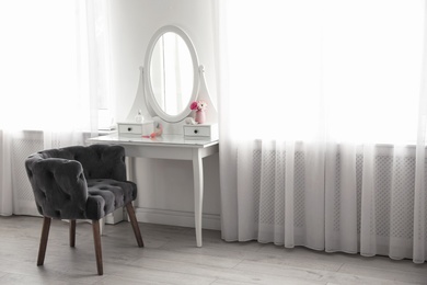 Elegant white dressing table and armchair in light room