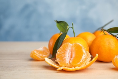 Fresh ripe tangerines with green leaves on table. Space for text