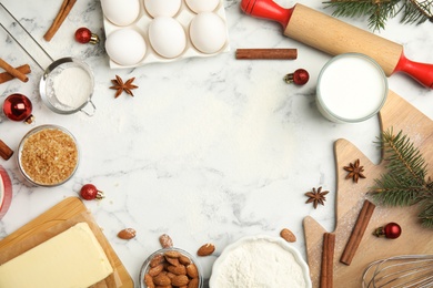 Flat lay composition with ingredients for traditional Christmas cake on white marble table. Space for text