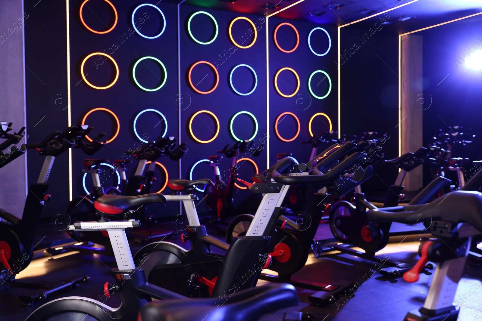 Photo of Many exercise bikes in fitness club. Indoor cycling class