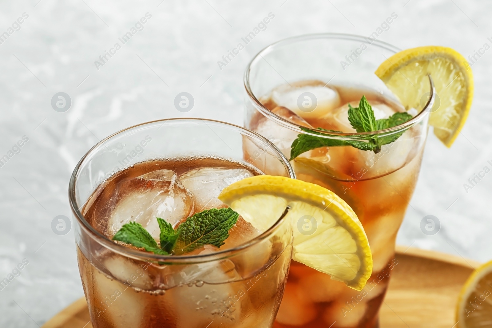 Photo of Glasses of delicious iced tea on marble table, closeup