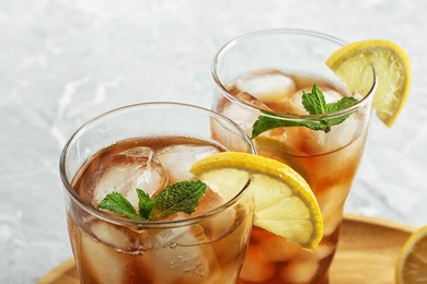 Glasses of delicious iced tea on marble table, closeup