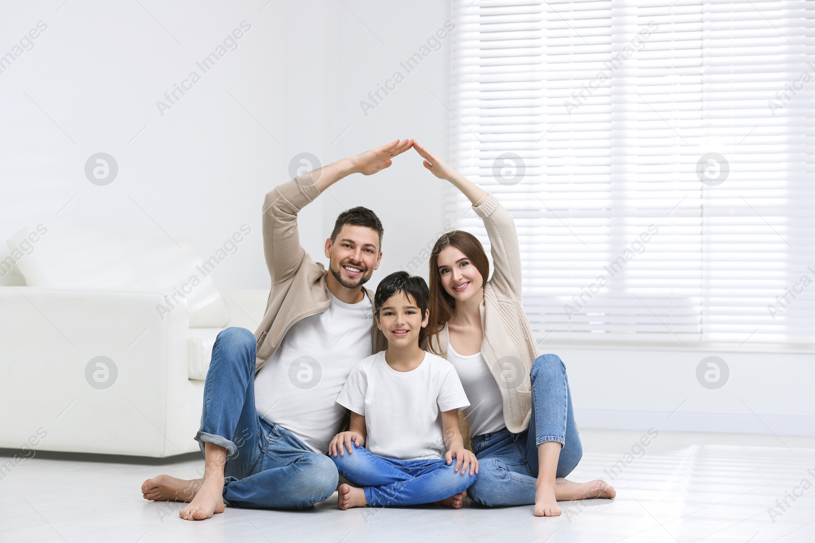 Photo of Happy family forming house roof with their hands at home. Insurance concept