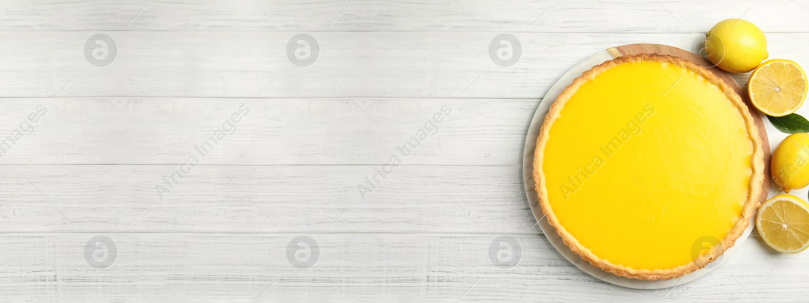 Photo of Delicious homemade lemon pie and fruits on white wooden table, flat lay. Space for text