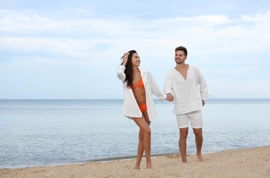 Photo of Happy young couple spending time together on beach