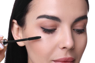 Photo of Beautiful young woman applying mascara on white background, closeup
