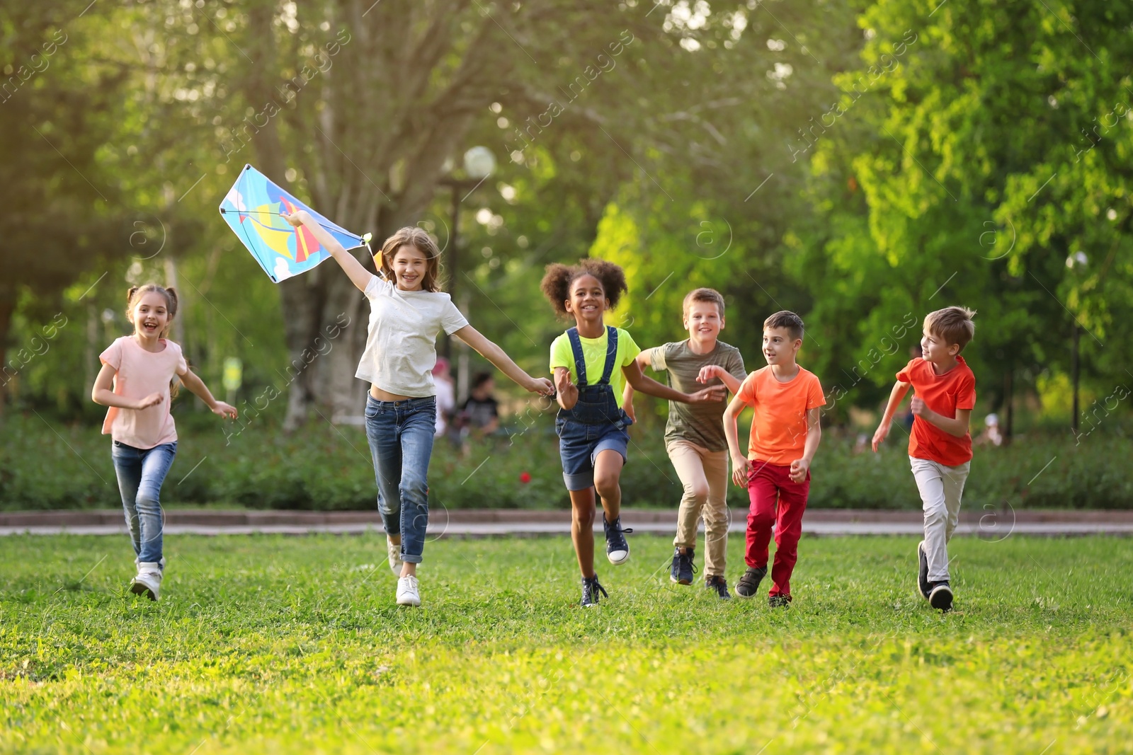 Photo of Cute little children playing with kite outdoors on sunny day