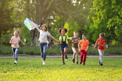 Cute little children playing with kite outdoors on sunny day