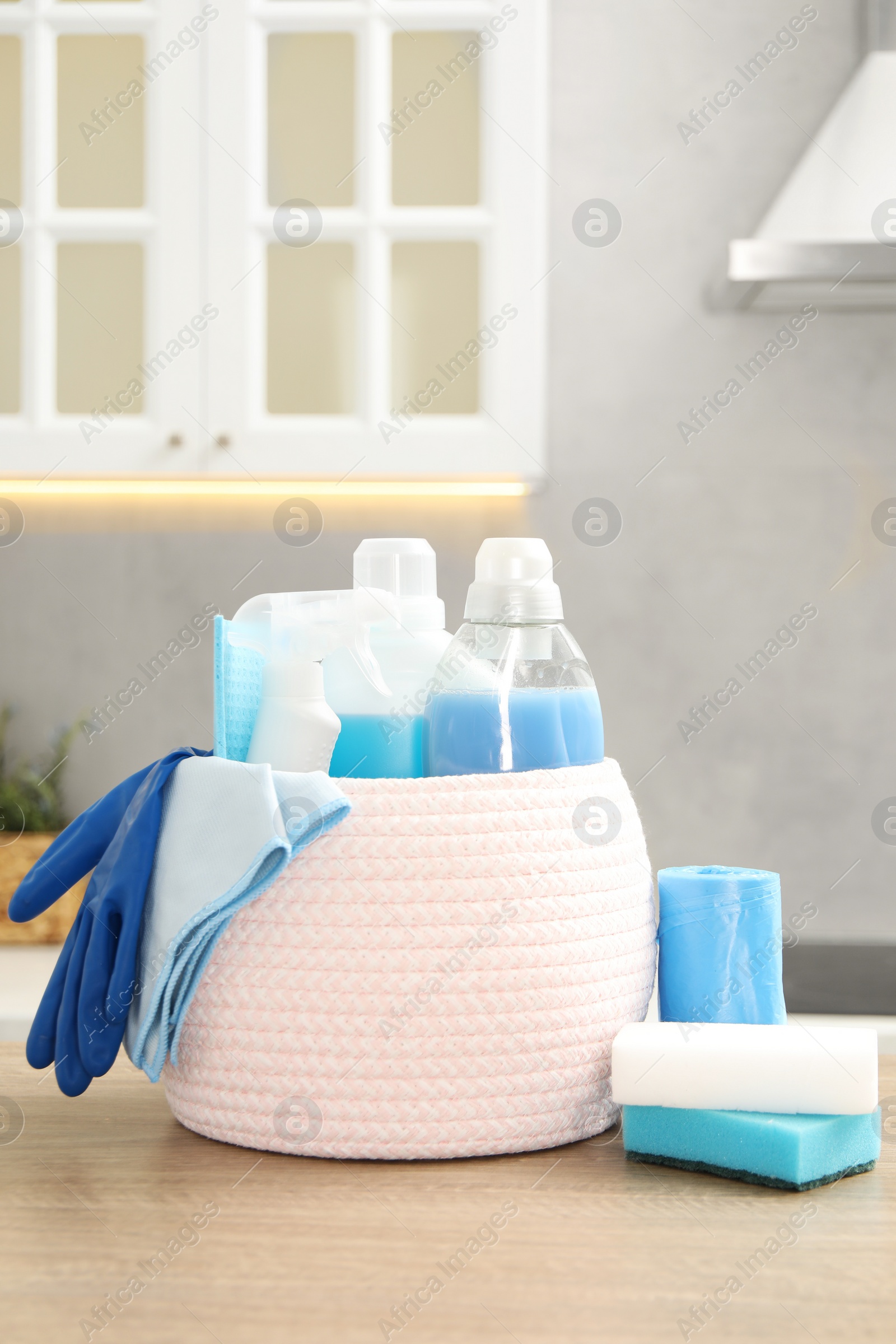 Photo of Different cleaning supplies in basket on table