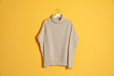 Photo of Hanger with stylish sweater on color background