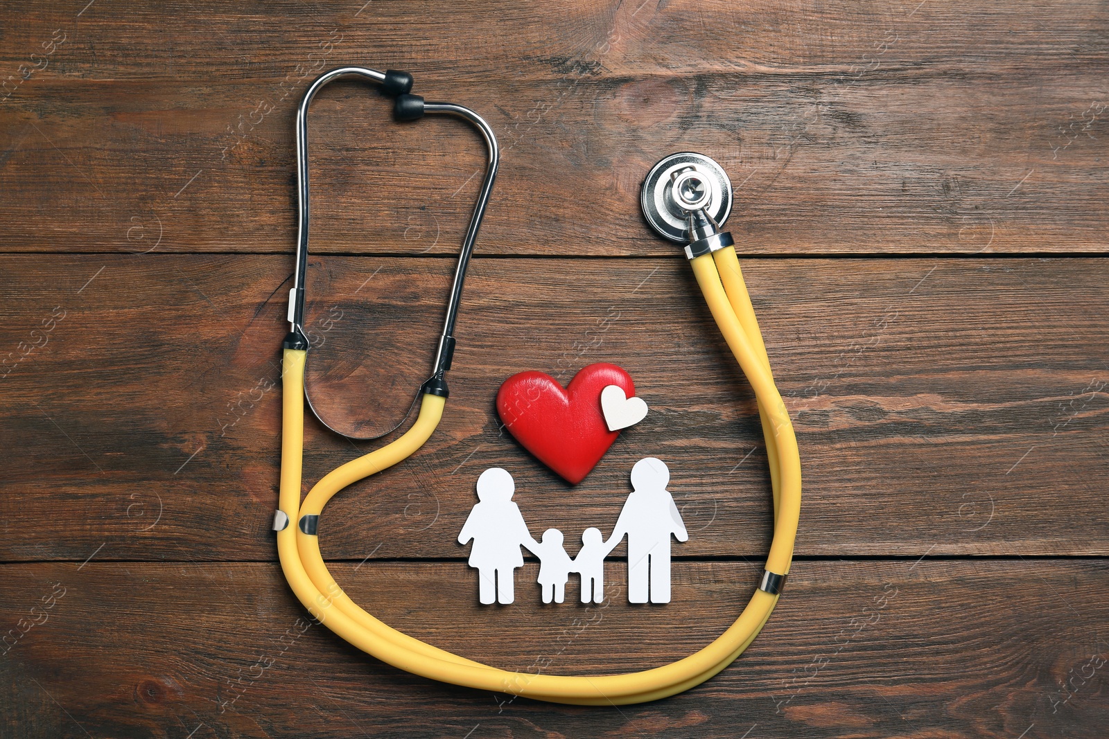 Photo of Flat lay composition with hearts, stethoscope and family silhouette on wooden background. Life insurance concept