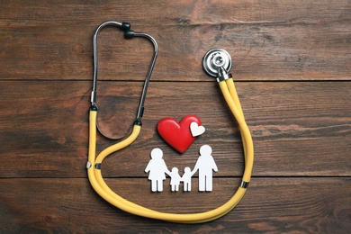 Photo of Flat lay composition with hearts, stethoscope and family silhouette on wooden background. Life insurance concept