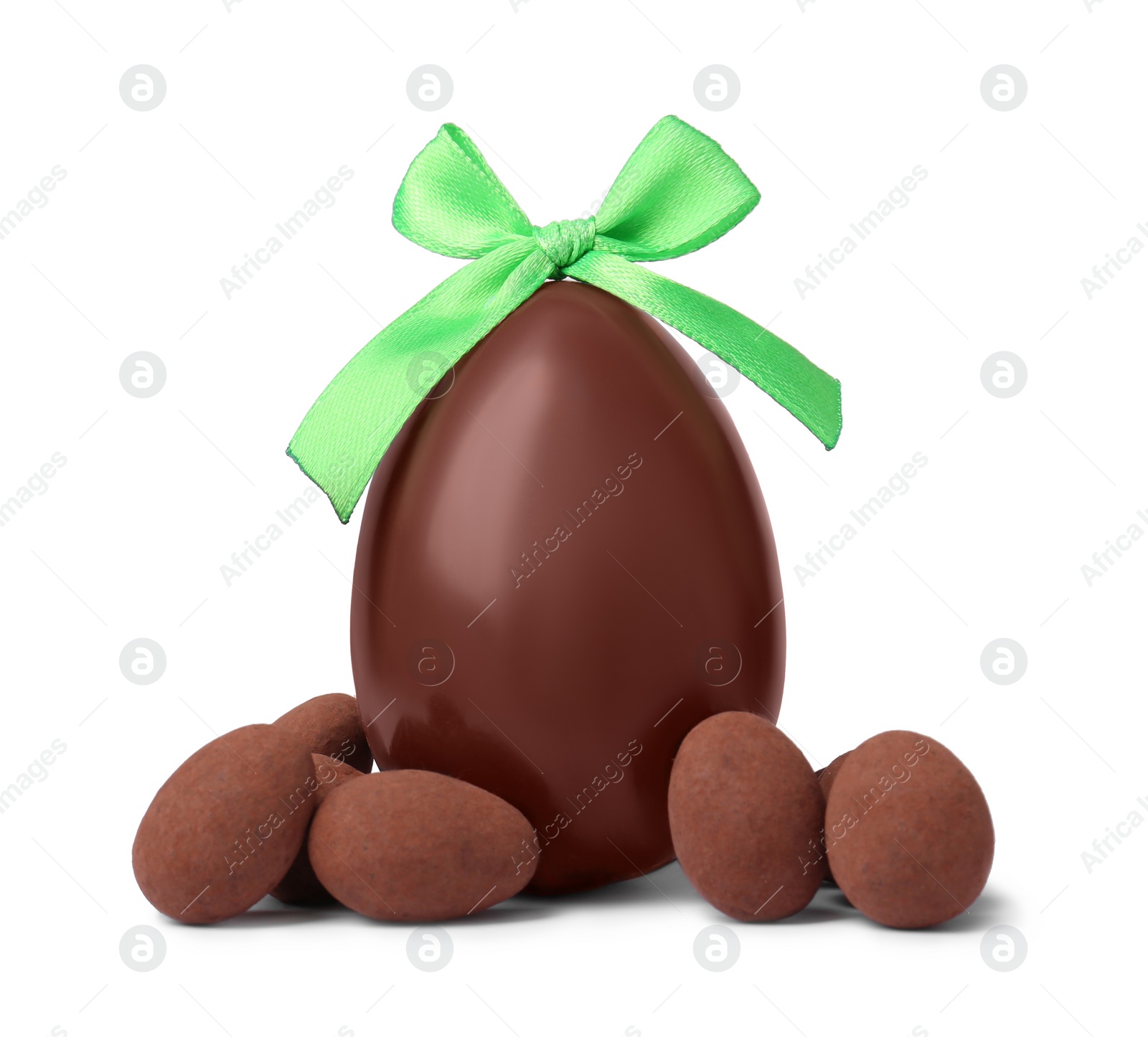 Photo of Tasty chocolate egg with green bow and candies isolated on white