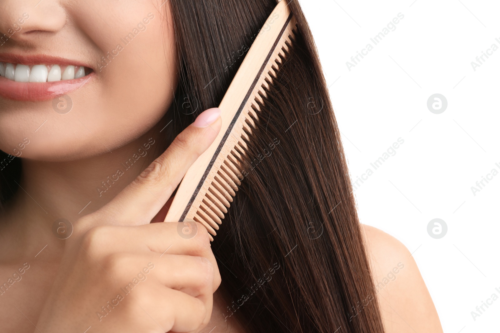 Photo of Young woman with wooden hair comb on white background, closeup