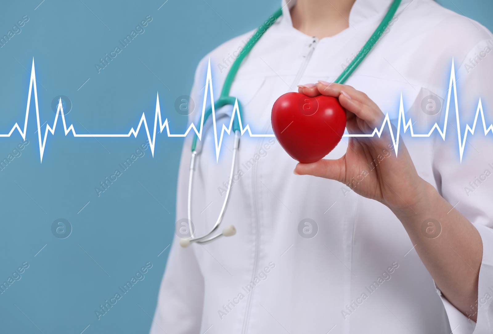 Image of Doctor holding red heart on light blue background, closeup 