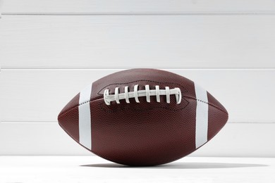 American football ball on white wooden background