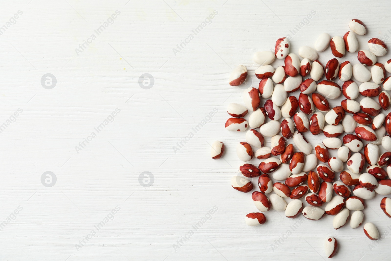 Photo of Raw beans and space for text on white wooden background, flat lay. Vegetable seeds