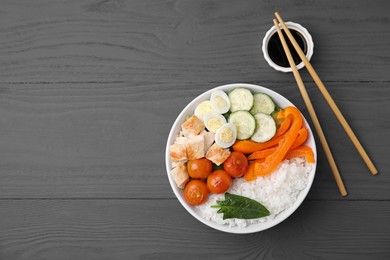 Photo of Delicious poke bowl with meat, rice, eggs and vegetables served on wooden table, flat lay. Space for text