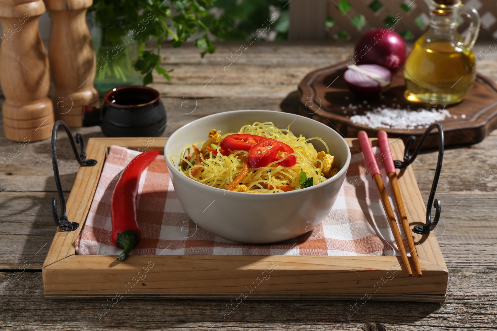 Photo of Stir-fry. Tasty noodles with vegetables and meat in bowl served on wooden table