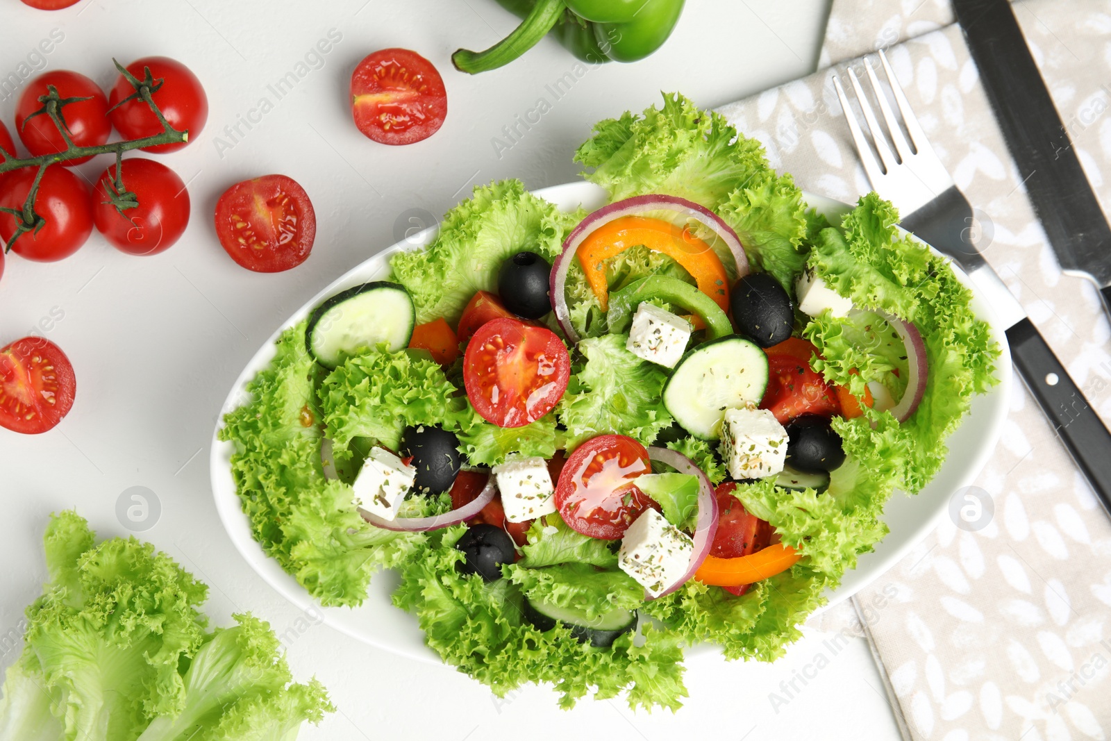 Photo of Tasty fresh Greek salad on white table, flat lay