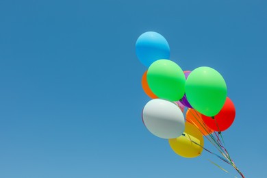 Bunch of colorful balloons against blue sky. Space for text