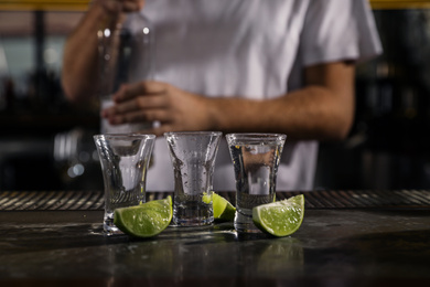 Mexican Tequila shots with lime slices on bar counter